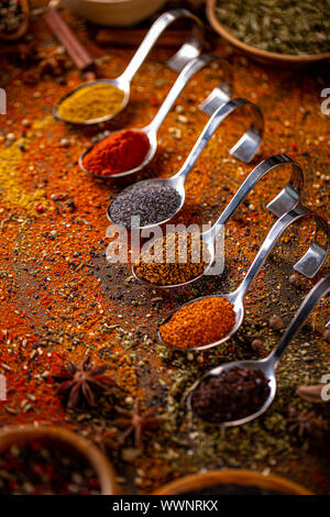 Different spices in spoons on table. Still life of spices and herbs Stock Photo