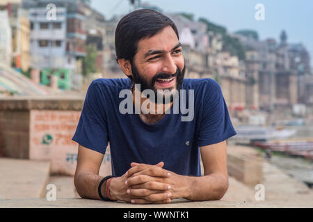 An Indian young man laughing and looking away in Varanasi, India. Stock Photo
