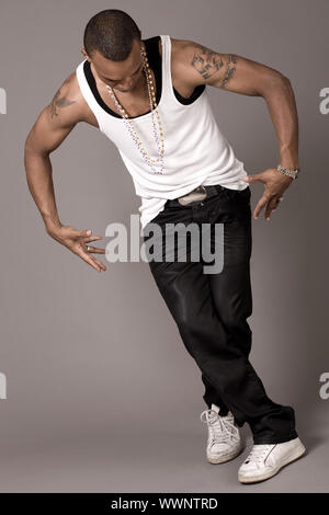 Break dancer in his steps on grey background Stock Photo