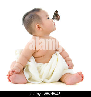 Butterfly flying to Asian baby boy nose, on white background Stock Photo