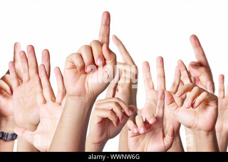 Group of people raising hands to answer a question Stock Photo