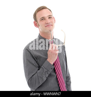 Thoughtful stylish young businessman standing with his glasses in his hands staring contemplatively at the camera as he assesses his decisions Stock Photo