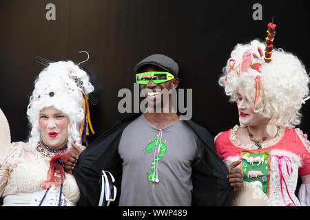 London, UK. 15th September 2019. Extinction Rebellion protesters from Bristol staging a demonstration at the London Fashion Week highlighting their concerns for the environment, dressed in old fashioned wigs and costumes with visual messages, here seen with a street fashionista at the fashion show. Credit: Joe Kuis / Alamy News Stock Photo