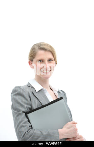 Smiling friendly young blonde female office worker or businesswoman holding a folio file in a stylish grey jacket Stock Photo