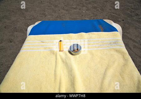 portable full ashtray with lighter on an hammock beach Stock Photo