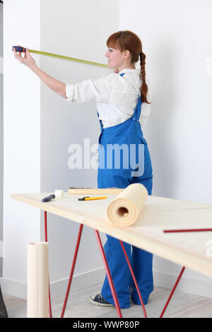 Female decorator measuring wall Stock Photo
