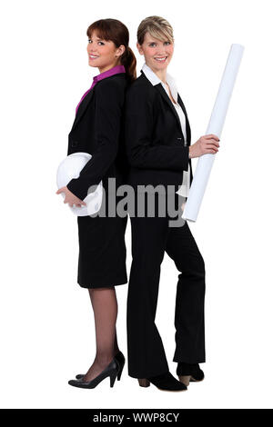 Two female architects standing back to back Stock Photo