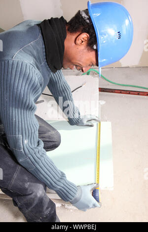 Man measuring plasterboard Stock Photo