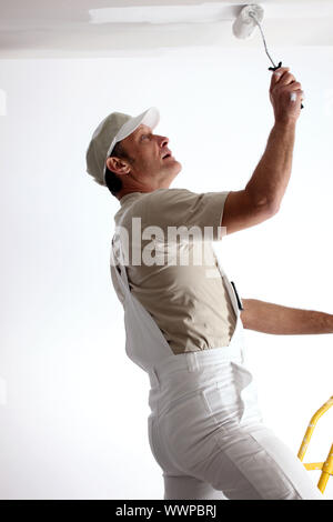 Man repainting ceiling with roller Stock Photo