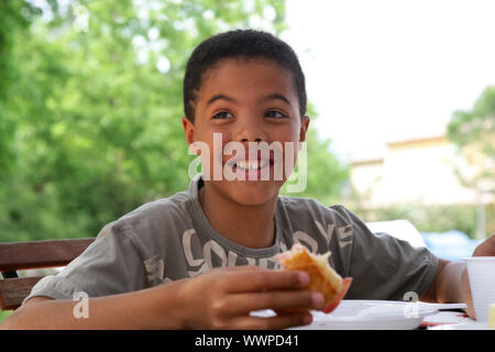 Child eating breakfast outside Stock Photo