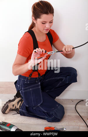 handywoman using stripping pliers on a wire Stock Photo