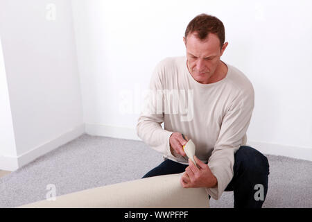 Man laying carpet Stock Photo