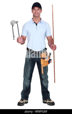 Plumber holding pipe and bending tool Stock Photo