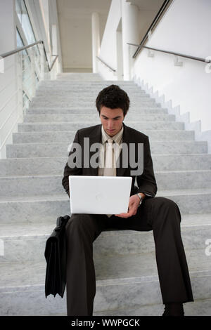 Businessman sat on the stairs Stock Photo