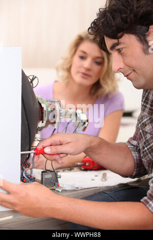 Man repairing broken television Stock Photo