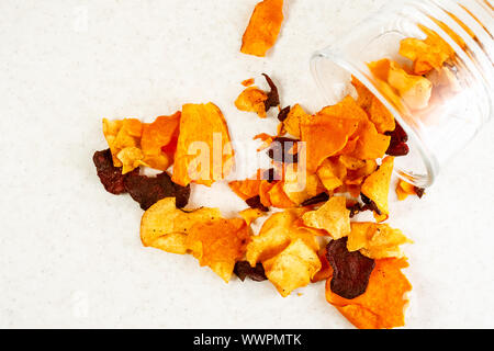Healthy snack from vegetable chips made from beetroot, carrot, parsnip on light colored background/ Top view, horizontal orientation with copy space Stock Photo