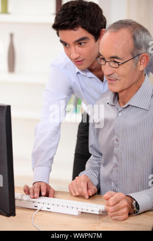 Man Computer Learing Teaching the younger generation. a young man and his father spending ...