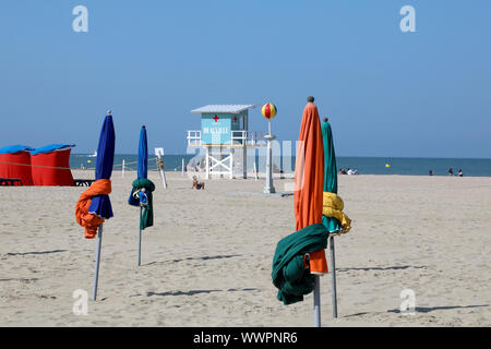 Deauville / France – September 14, 2019: Furled sunshades and a lifeguard tower on Deauville beach Stock Photo