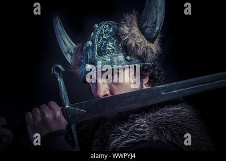 Danger, Viking warrior with a huge sword and helmet with horns Stock Photo