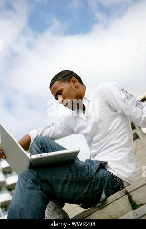 Man sat on steps using wireless connection Stock Photo