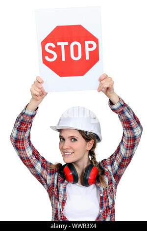 Female builder holding stop sign Stock Photo