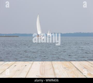 blurry lake abstraction with wooden planks floor and yacht Stock Photo