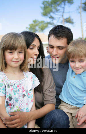 Family sat together in the garden Stock Photo