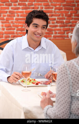 a boy and his grandmother at restaurant Stock Photo