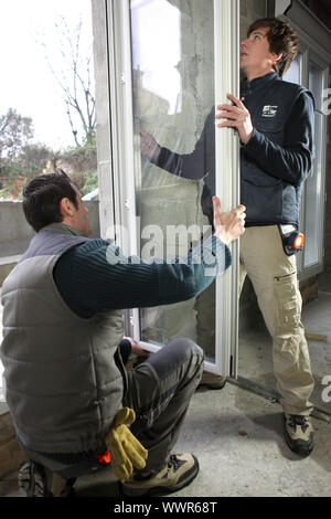 Two workers fitting window Stock Photo
