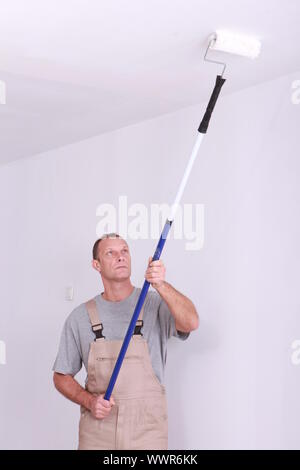 Man repainting ceiling Stock Photo