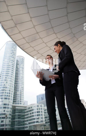 Two businesswomen stood outside high-rise building Stock Photo