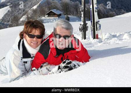 Couple lying in the snow Stock Photo