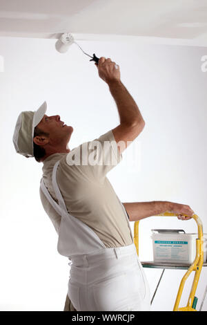 Painter using roller on ceiling Stock Photo