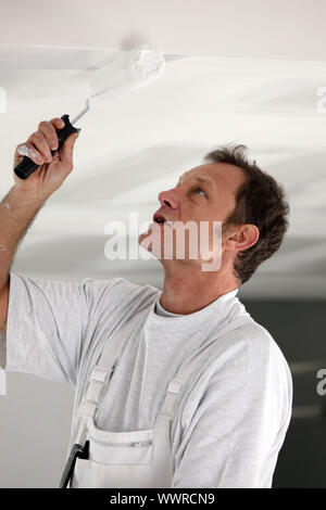 Painter repainting ceiling Stock Photo