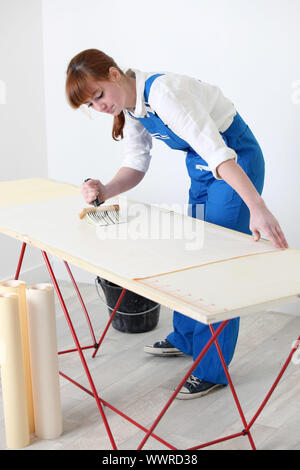 Woman pasting wall paper Stock Photo