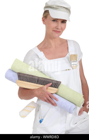 Female decorator holding rolls of wallpaper Stock Photo