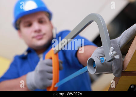 Plumbing sawing plastic pipe Stock Photo