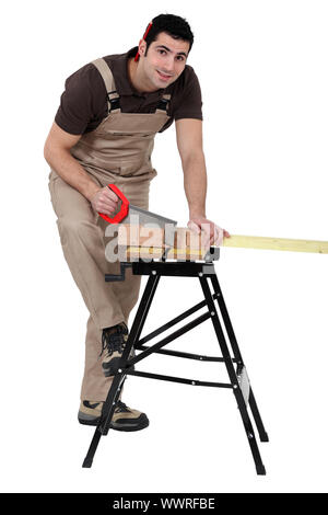 Man using miter to saw wood Stock Photo