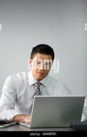 Young salesman sat at desk Stock Photo