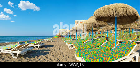 Panoramic view to sun loungers and straw parasols on a beach. Torremolinos, Costa del Sol, Andalucia, Spain Stock Photo