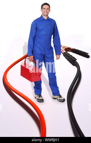 Tradesman surrounded by jumper cables Stock Photo