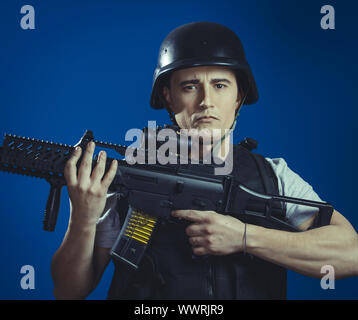 Recreation, paintball sport player wearing protective helmet aiming pistol ,black armor and machine gun Stock Photo