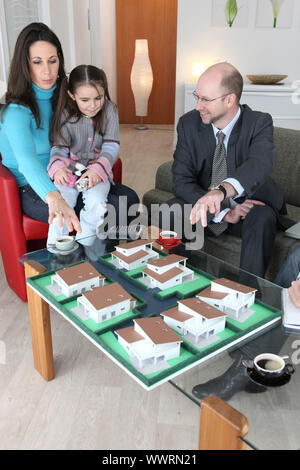 Architect showing model housing to mother and daughter Stock Photo