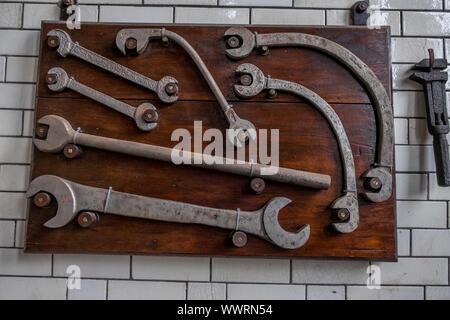 Various sized spanners and assorted tools in engineers workshop. Stock Photo