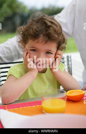 Child drinking a class of freshly squeezed orange juice Stock Photo