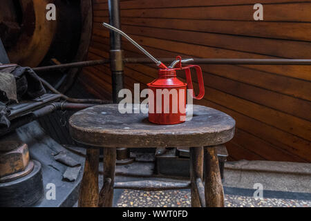 Red oil can in an engineering workshop. Stock Photo