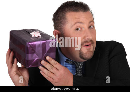 Businessman trying to guess what's inside his gift Stock Photo