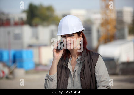 female architect making a call in construction site Stock Photo