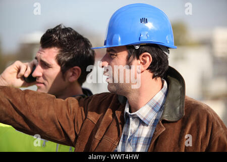 construction supervisor and assistant observing Stock Photo