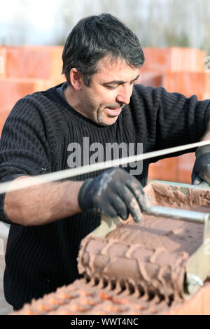 Mason using special device to pour cement on wall Stock Photo